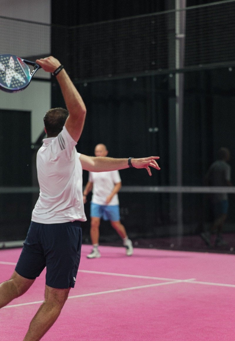 Padel player mid-shot on a pink court, for Padel League UK