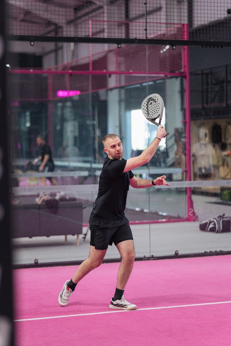 Padel player swinging on a pink court, for Padel League UK
